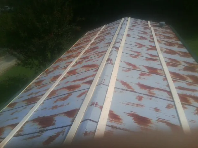 Rusted metal roof panels with new wood purlins before replacement — Storm Damage Roof Repair in Cumberland by Roofing Brothers